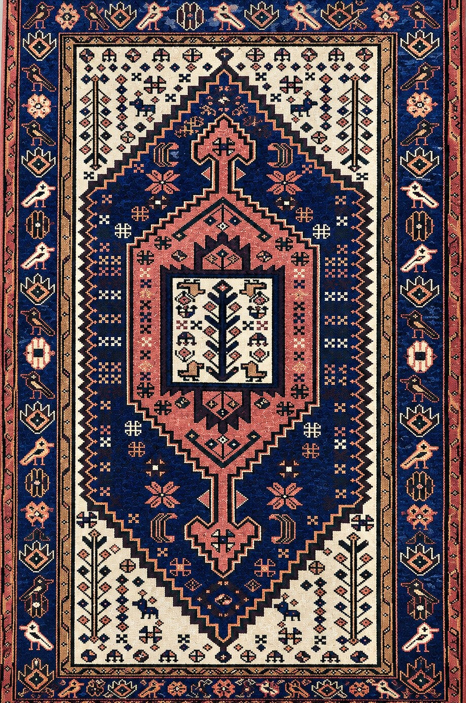 A traditional oriental-style Heriz area rug with a complex geometric and floral pattern. The design features a large central medallion in dusty pink and cream, surrounded by a deep navy blue field, and a wide patterned border in dark blue, rust red, and cream.