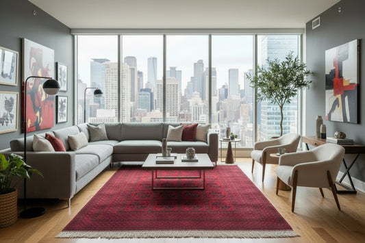 Red patterned rug with white fringe on a concrete floor