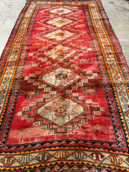 Traditional red patterned rug with geometric designs on a plain background