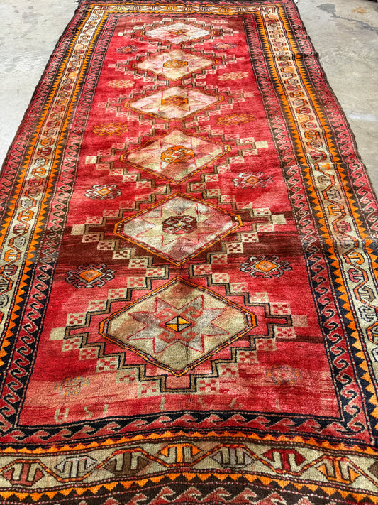 Traditional red patterned rug with geometric designs on a plain background