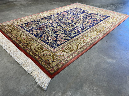 Decorative 3x5 silk Persian Qum rug with intricate patterns on a concrete floor