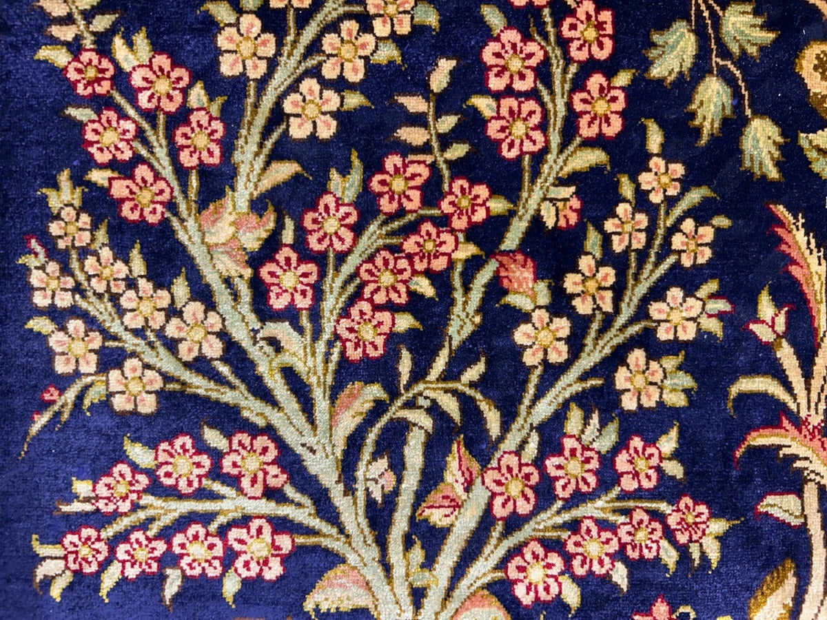 Floral patterned rug with pink and yellow flowers on a dark blue background